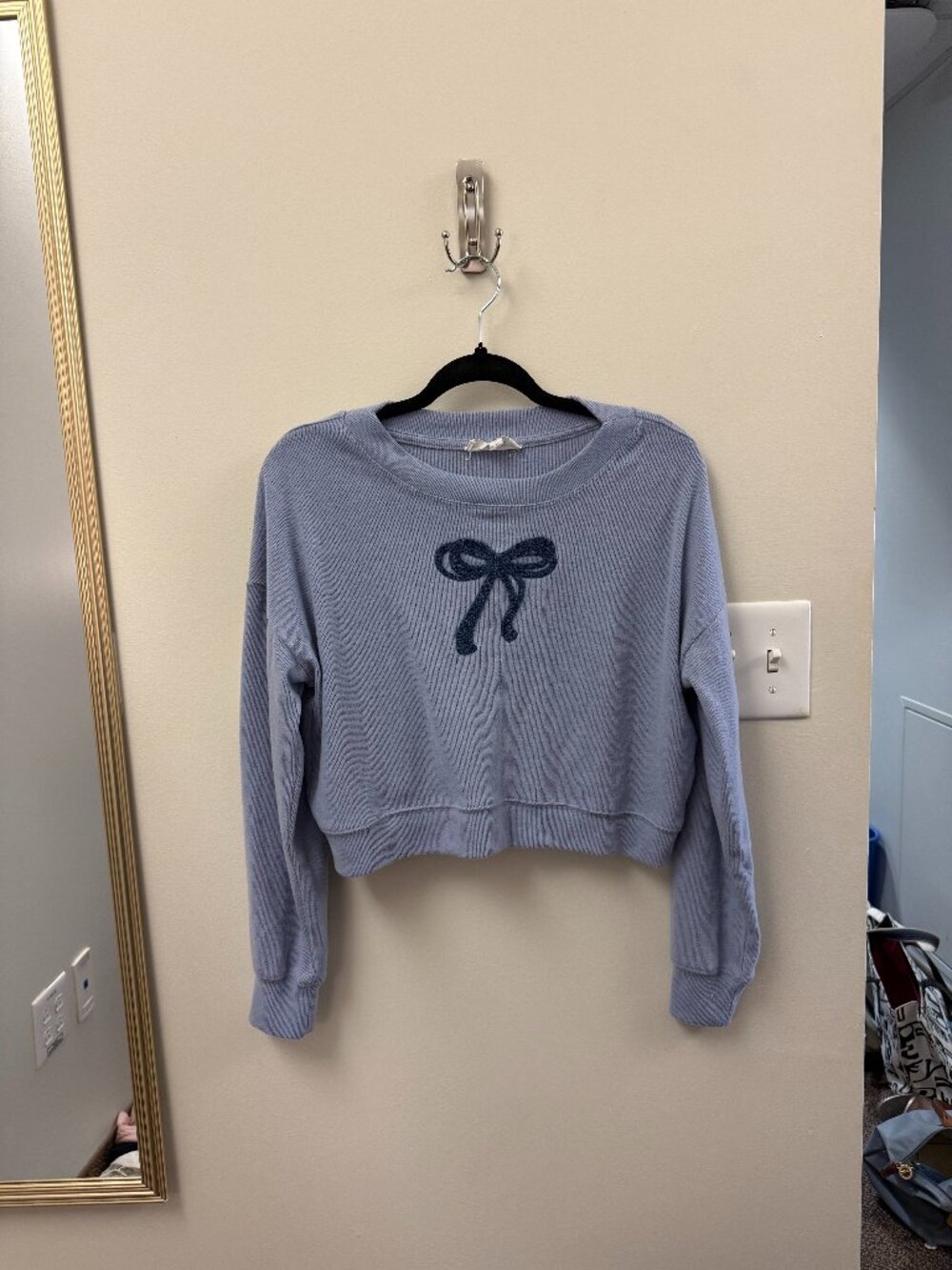 light blue sweater with darker blue bow detail